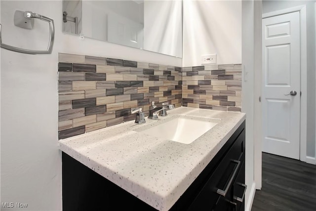 interior space with vanity, wood finished floors, and decorative backsplash