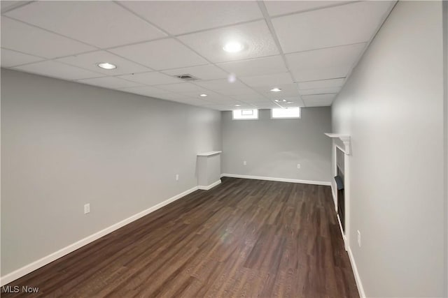 basement with dark wood-type flooring, visible vents, and baseboards