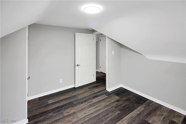 bonus room featuring dark wood-style flooring, baseboards, and lofted ceiling