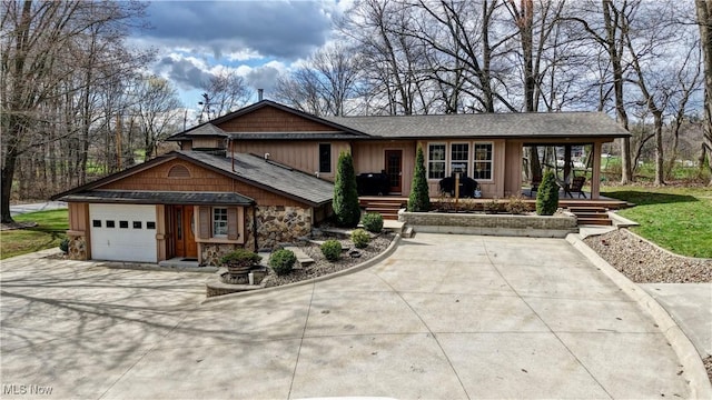 7345 Township Road 319, Millersburg, OH 44654 - view of front of property featuring concrete driveway, a shingled roof, stone siding, and an attached garage
