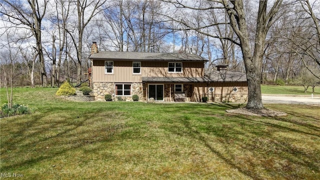 7345 Township Road 319, Millersburg, OH 44654 - view of front facade with board and batten siding, a chimney, a front yard, and stone siding