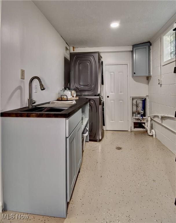 7345 Township Road 319, Millersburg, OH 44654 - clothes washing area featuring cabinet space, stacked washer / dryer, and a sink