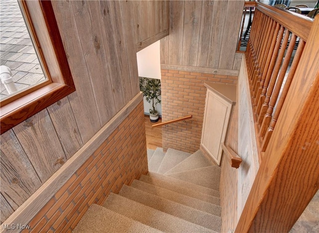 7345 Township Road 319, Millersburg, OH 44654 - staircase with brick wall, wooden walls, and wood finished floors