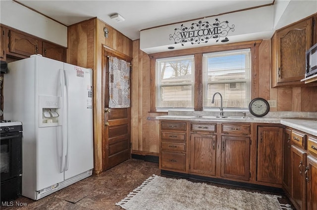 2510 E Midlothian Blvd, Youngstown, OH 44502 - kitchen featuring white fridge with ice dispenser, a sink, light countertops, black range oven, and brown cabinetry