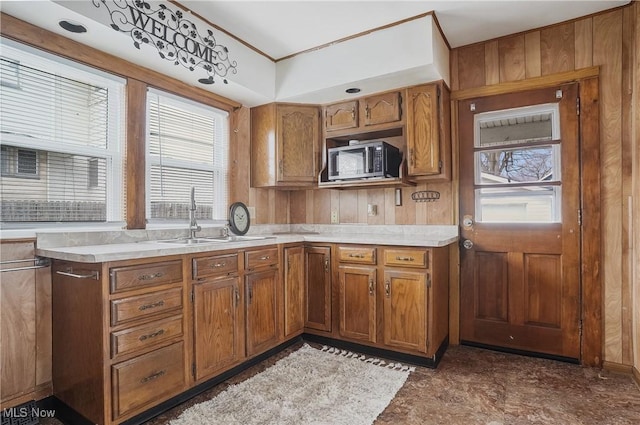 2510 E Midlothian Blvd, Youngstown, OH 44502 - kitchen with stainless steel microwave, brown cabinets, light countertops, and wood walls