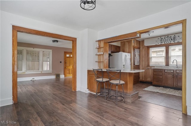 2510 E Midlothian Blvd, Youngstown, OH 44502 - kitchen featuring white fridge with ice dispenser, dark wood-style flooring, brown cabinetry, and a sink