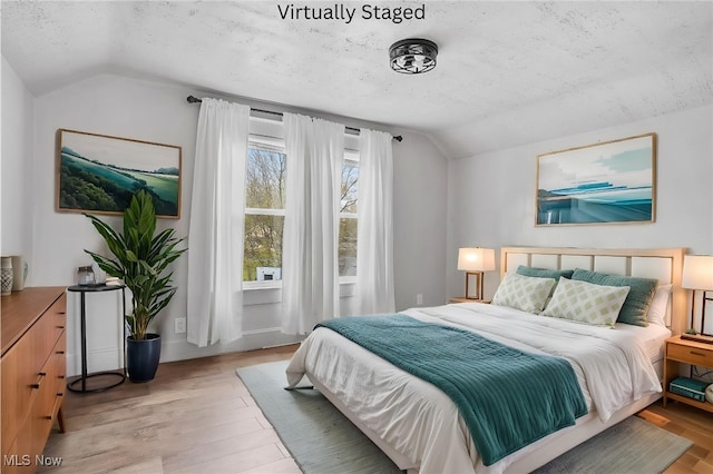 2510 E Midlothian Blvd, Youngstown, OH 44502 - bedroom with vaulted ceiling, a textured ceiling, and light wood-style floors
