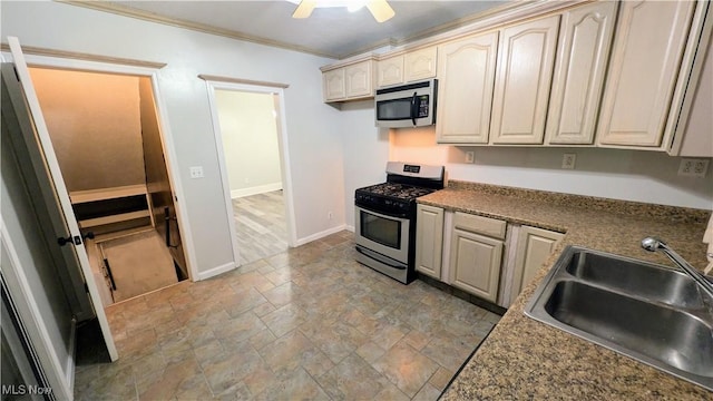 kitchen featuring baseboards, a sink, stone tile flooring, appliances with stainless steel finishes, and crown molding
