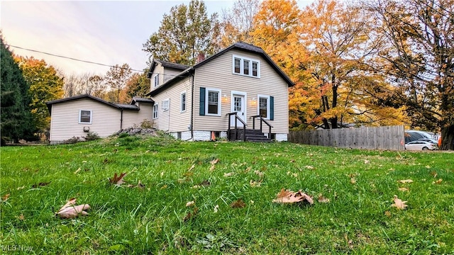 view of front of home with a front yard and fence