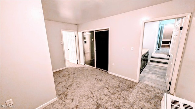 unfurnished bedroom featuring a closet, carpet flooring, and baseboards