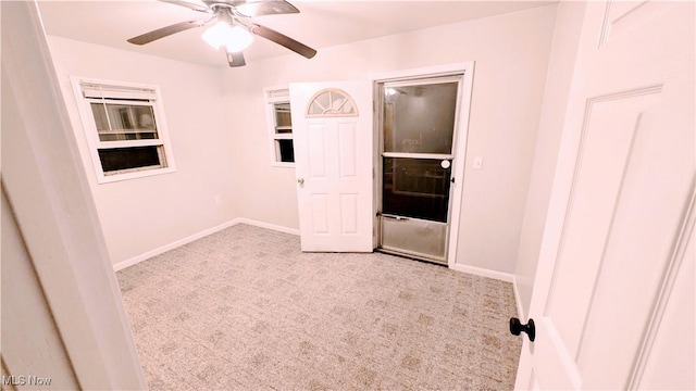 carpeted empty room with ceiling fan and baseboards