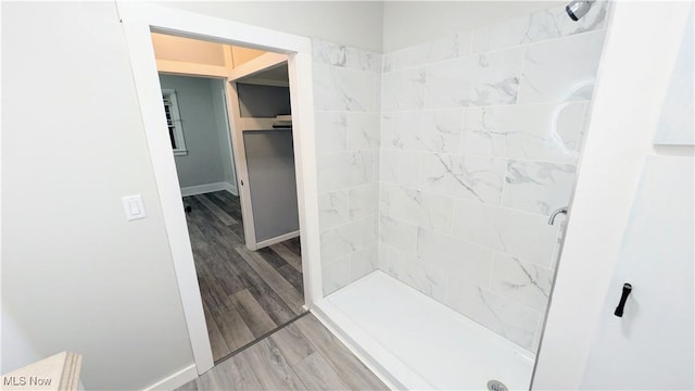 bathroom featuring a shower stall, wood finished floors, and baseboards