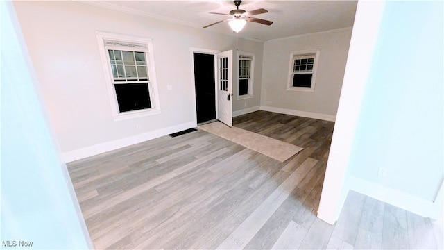 unfurnished room featuring crown molding, ceiling fan, wood finished floors, and baseboards