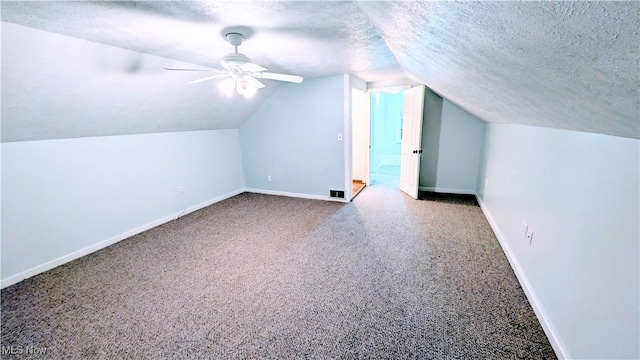 bonus room with carpet floors, baseboards, and a textured ceiling