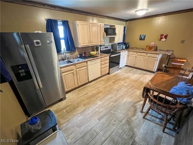 106 N Surry Rd, East Liverpool, OH 43920 - kitchen with stainless steel appliances, light wood finished floors, a sink, and crown molding