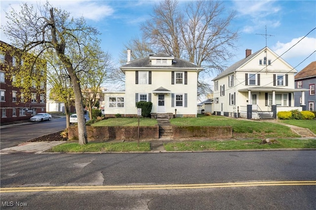 traditional style home featuring a front lawn