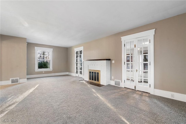 unfurnished living room with visible vents, carpet flooring, and a fireplace