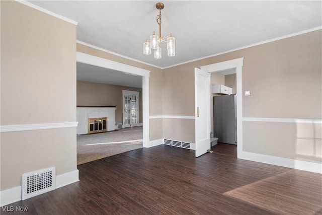 unfurnished dining area featuring a chandelier, baseboards, dark wood finished floors, and visible vents