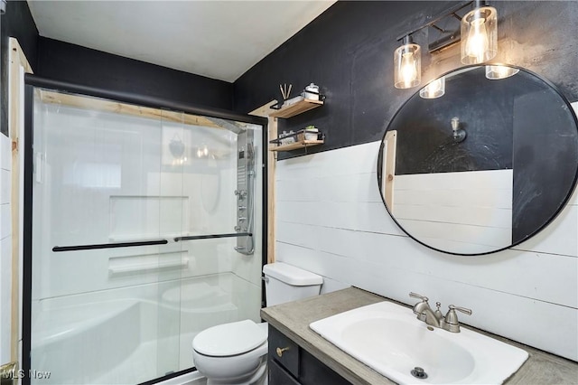 full bathroom featuring toilet, a stall shower, and vanity