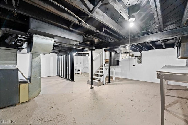 unfinished basement featuring stairs and heating unit