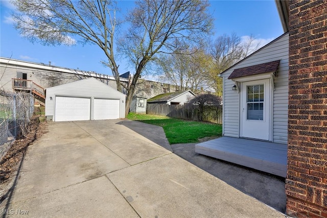 view of yard with an outbuilding, a detached garage, and fence