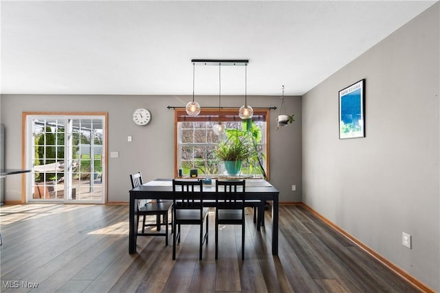 dining space with dark wood-style flooring and baseboards