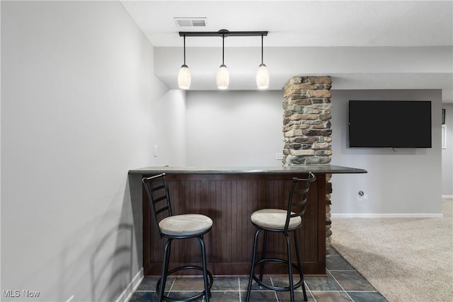 bar featuring visible vents, baseboards, dark carpet, a dry bar, and pendant lighting