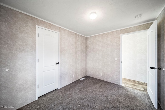 53 Martha Dr, Madison, OH 44057 - empty room with a textured ceiling, dark carpet, and ornamental molding