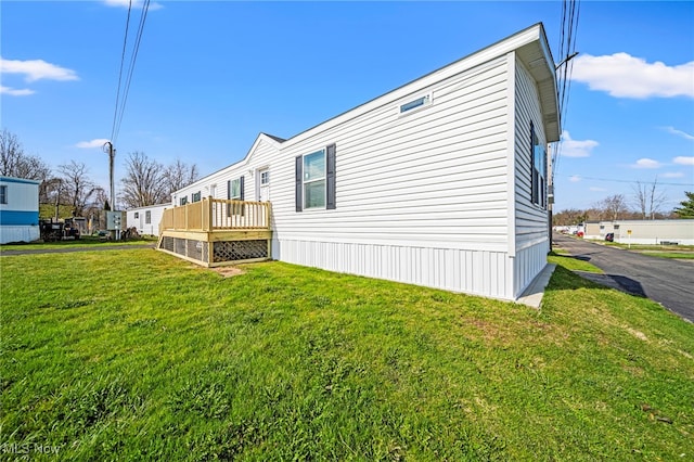 53 Martha Dr, Madison, OH 44057 - view of side of property with a wooden deck and a lawn