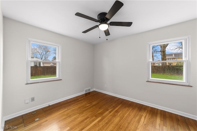 unfurnished room with light wood-style floors, ceiling fan, baseboards, and visible vents