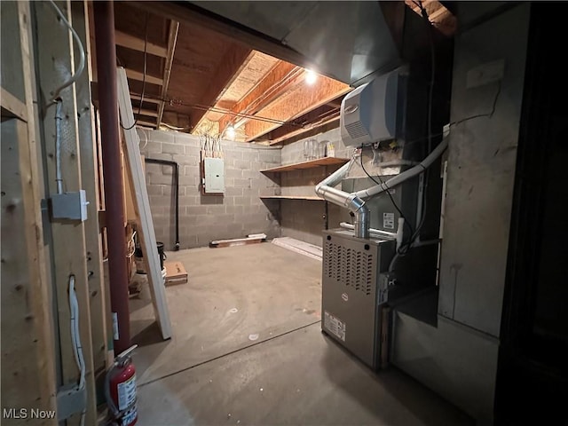 unfinished below grade area featuring electric panel and concrete block wall