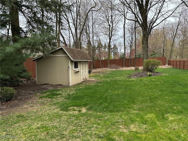 view of yard featuring an outbuilding, a fenced backyard, and a storage unit