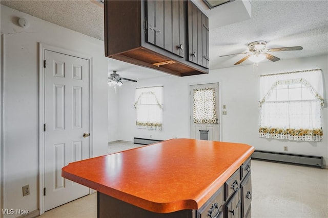 304 Conger Rd, Washington, WV 26181 - kitchen featuring a center island, a baseboard heating unit, a textured ceiling, and ceiling fan