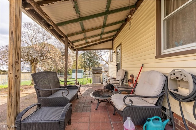 view of patio / terrace featuring an outdoor fire pit, area for grilling, fence, and an outdoor structure