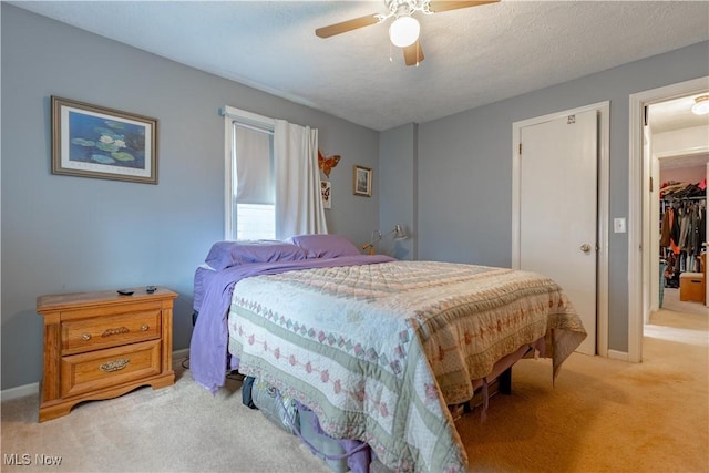 bedroom with light carpet, a closet, baseboards, and ceiling fan