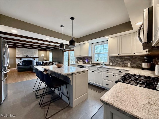21 Ashwood Dr, Vienna, WV 26105 - kitchen with a sink, backsplash, open floor plan, stainless steel appliances, and white cabinetry