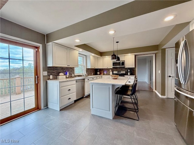 21 Ashwood Dr, Vienna, WV 26105 - kitchen featuring appliances with stainless steel finishes, a sink, decorative backsplash, a kitchen island, and a breakfast bar