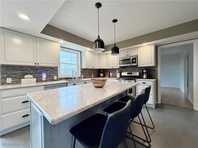21 Ashwood Dr, Vienna, WV 26105 - kitchen with appliances with stainless steel finishes, decorative backsplash, a sink, a kitchen bar, and a kitchen island