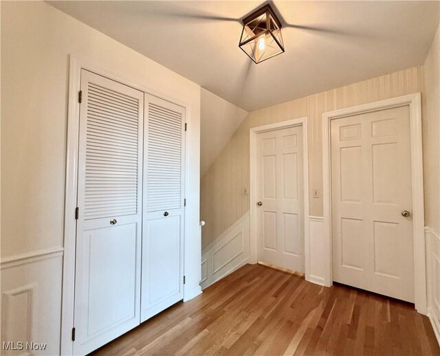 21 Ashwood Dr, Vienna, WV 26105 - unfurnished bedroom featuring light wood-style floors, a closet, lofted ceiling, and a decorative wall