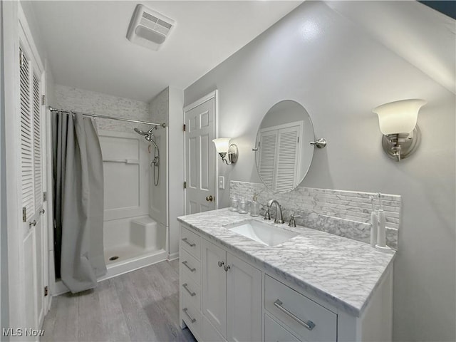 21 Ashwood Dr, Vienna, WV 26105 - bathroom with a shower with shower curtain, vanity, wood finished floors, and backsplash