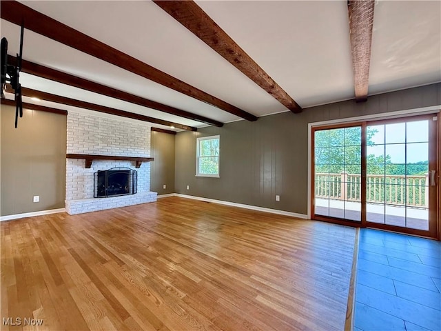 21 Ashwood Dr, Vienna, WV 26105 - unfurnished living room featuring beamed ceiling, light wood finished floors, baseboards, and a brick fireplace