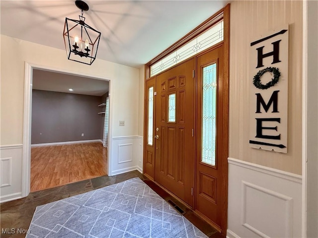 21 Ashwood Dr, Vienna, WV 26105 - foyer entrance with a chandelier, a wainscoted wall, healthy amount of natural light, and a decorative wall