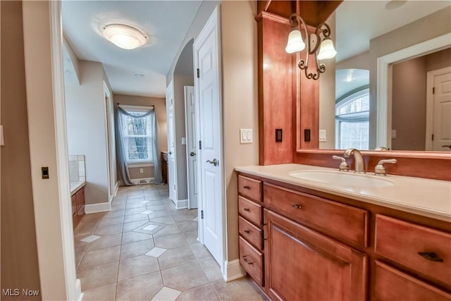 bathroom featuring baseboards, a healthy amount of sunlight, tile patterned floors, and vanity