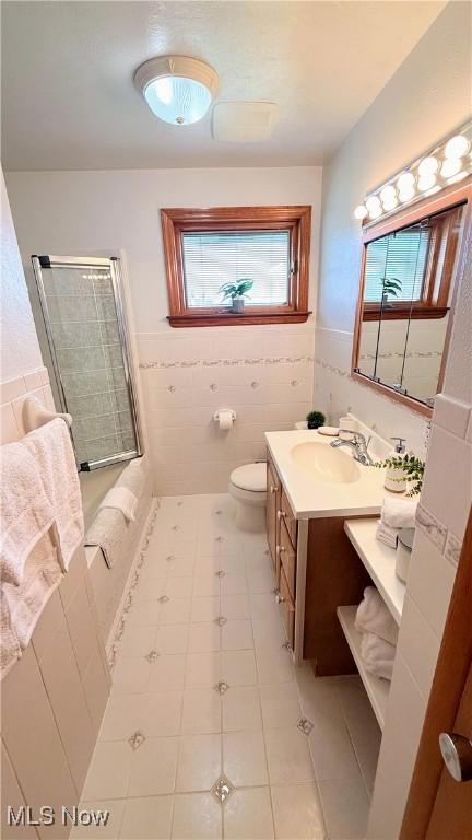 126 Vine St, Mingo Junction, OH 43938 - bathroom featuring a tile shower, vanity, toilet, tile walls, and tile patterned floors