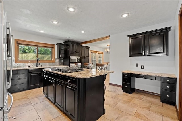5215 Glenbrook Dr, Vienna, WV 26105 - kitchen featuring gas cooktop, stainless steel microwave, a sink, dark cabinetry, and backsplash