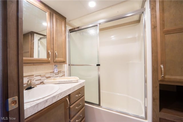 bathroom with combined bath / shower with glass door, vanity, recessed lighting, and backsplash