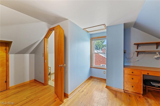 bonus room featuring attic access, lofted ceiling, light wood finished floors, and baseboards