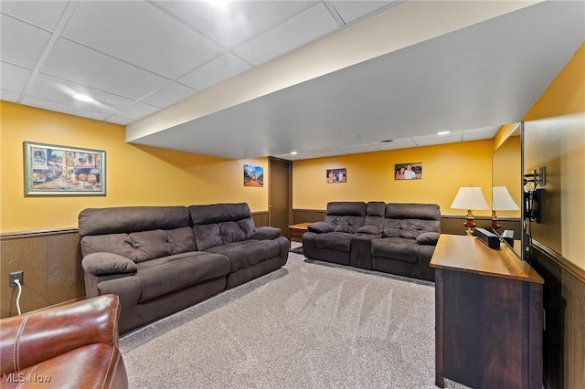 living area with carpet flooring, a drop ceiling, and wainscoting