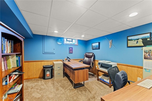 office space with wooden walls, carpet floors, a wainscoted wall, and a paneled ceiling