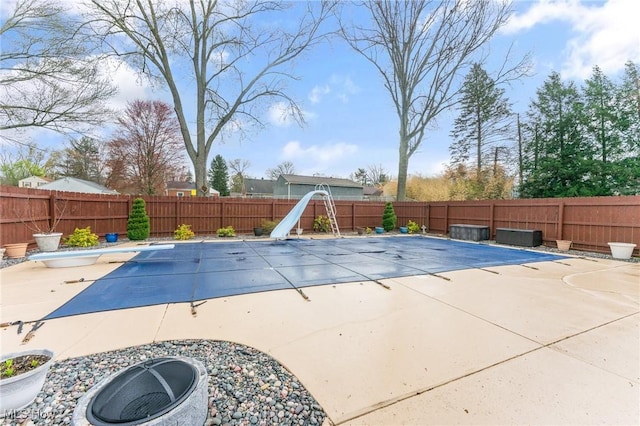view of pool with a fenced backyard, a water slide, a diving board, and a fenced in pool